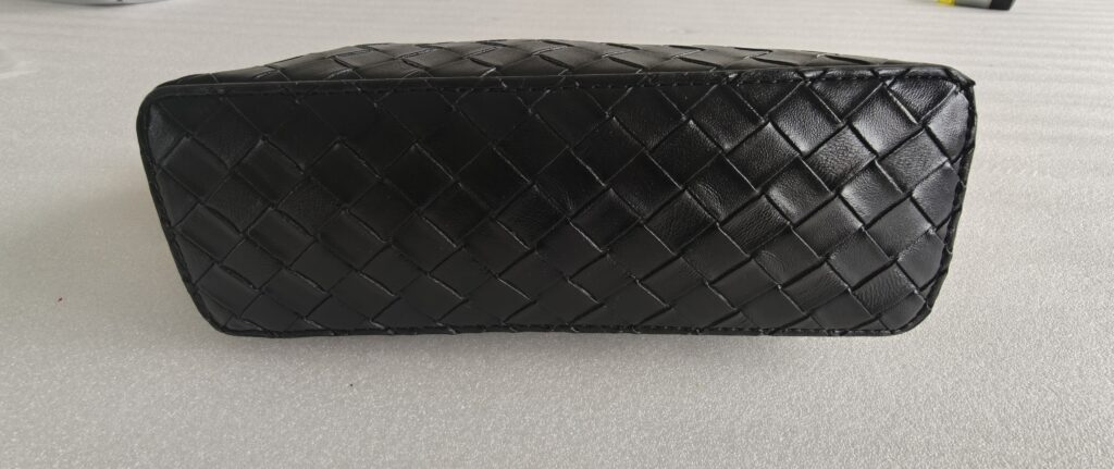 Custom black woven handbag quality inspection showing bag structure surface and stitching details.
