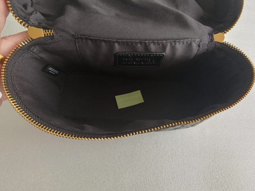 Interior quality inspection of custom handbag lining inner label and zipper opening.