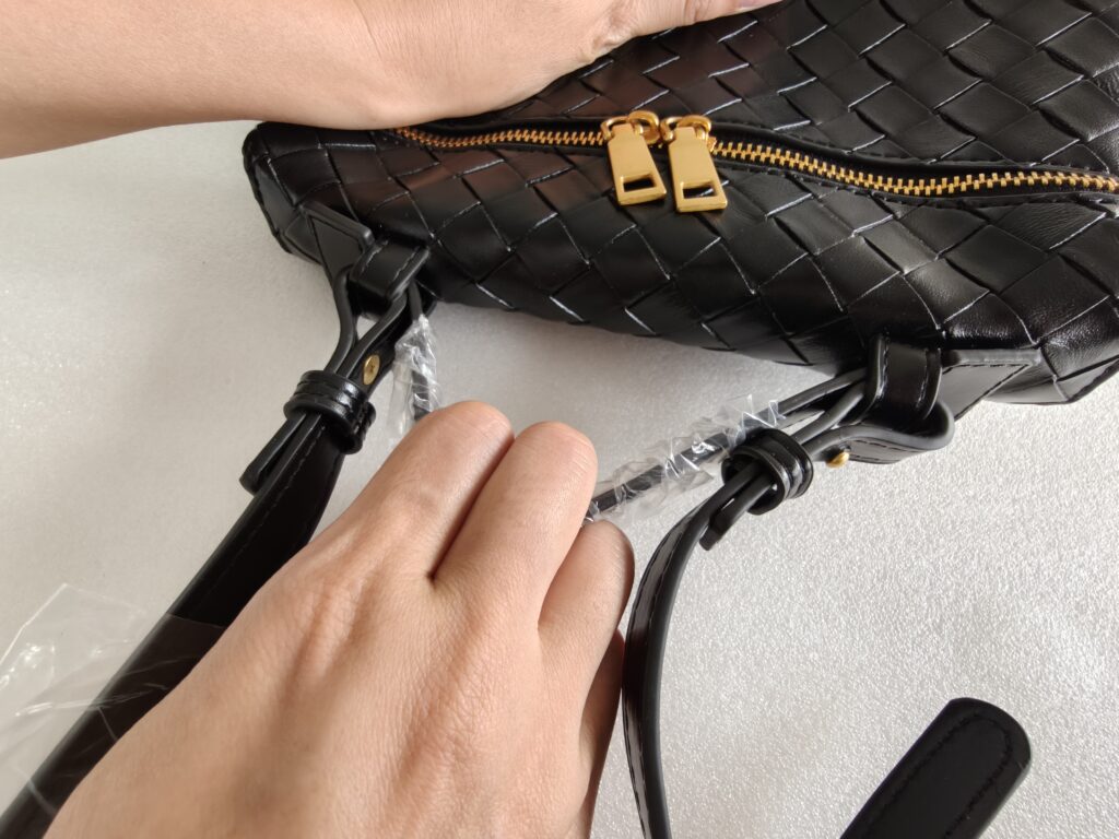 Handbag handle strength inspection during custom bag quality control.
