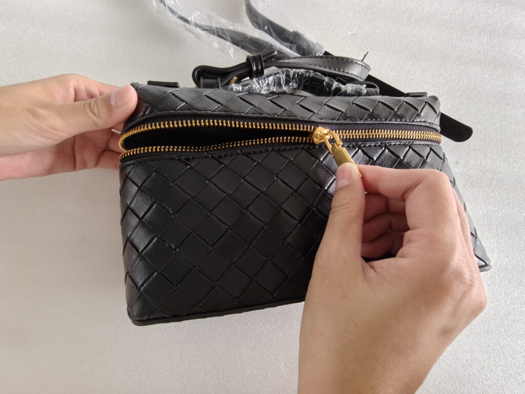 Custom bag zipper function inspection showing zipper movement and hardware quality control.