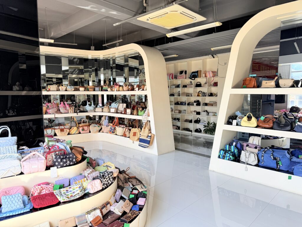 Custom bag manufacturer showroom with handbags crossbody bags wallets belts backpacks and accessories.
